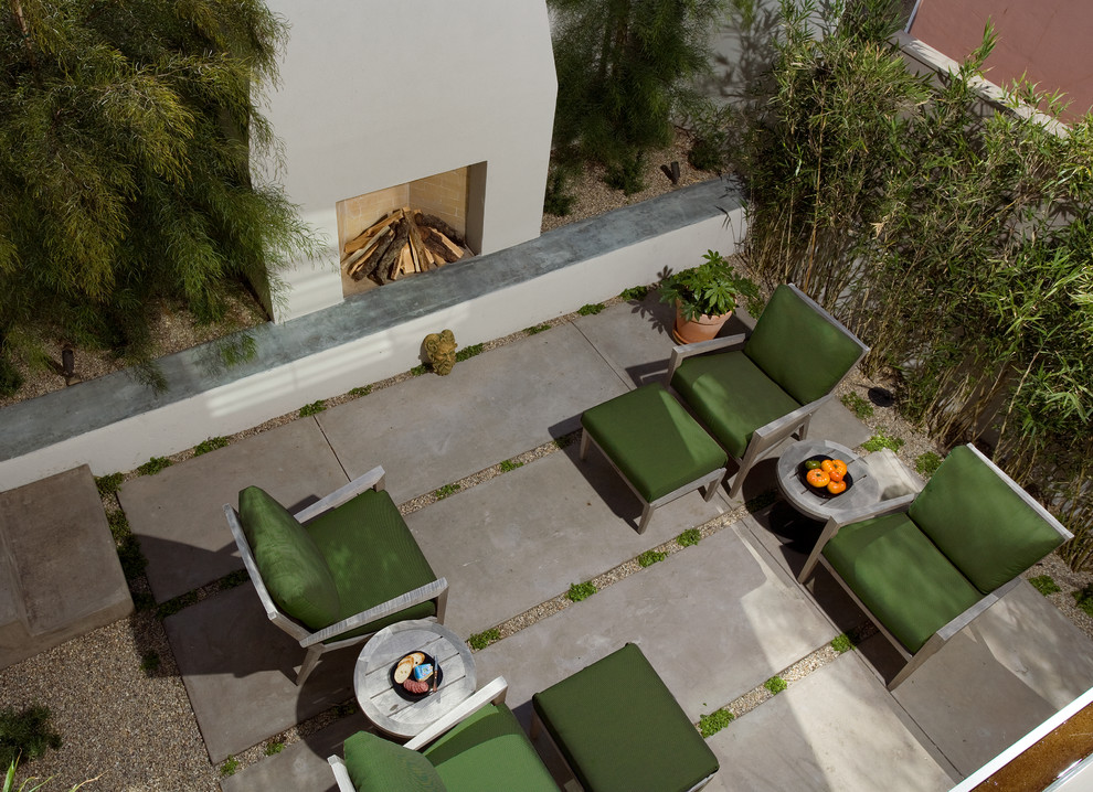 Modelo de patio minimalista de tamaño medio sin cubierta en patio trasero con brasero y losas de hormigón