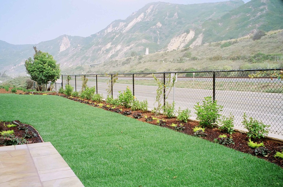 Exemple d'une terrasse avec des plantes en pots arrière chic de taille moyenne avec des pavés en pierre naturelle et aucune couverture.