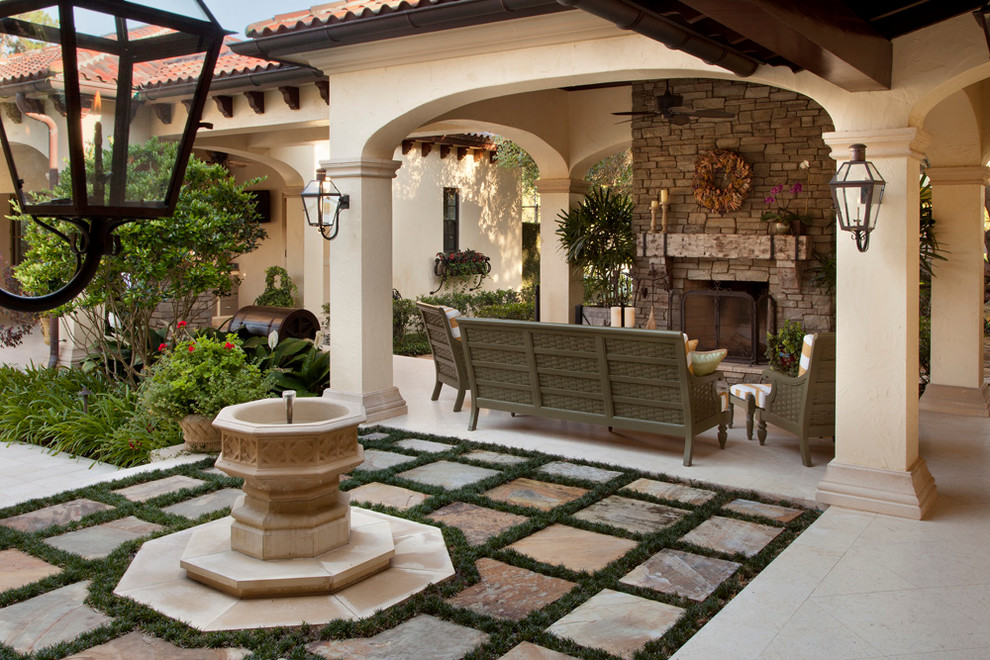 Mediterranean patio in Tampa with a water feature and no cover.