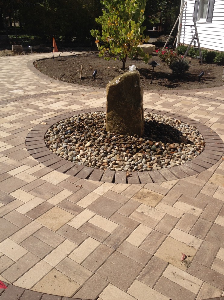Inspiration for a mid-sized contemporary front yard brick patio fountain remodel in Cleveland