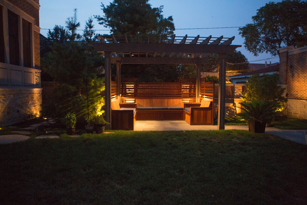 Example of a mid-sized classic backyard stone patio design in Chicago with a pergola