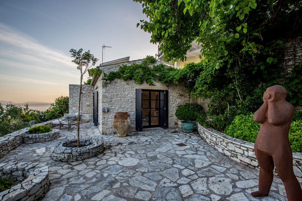 Imagen de patio mediterráneo sin cubierta con ducha exterior y adoquines de piedra natural