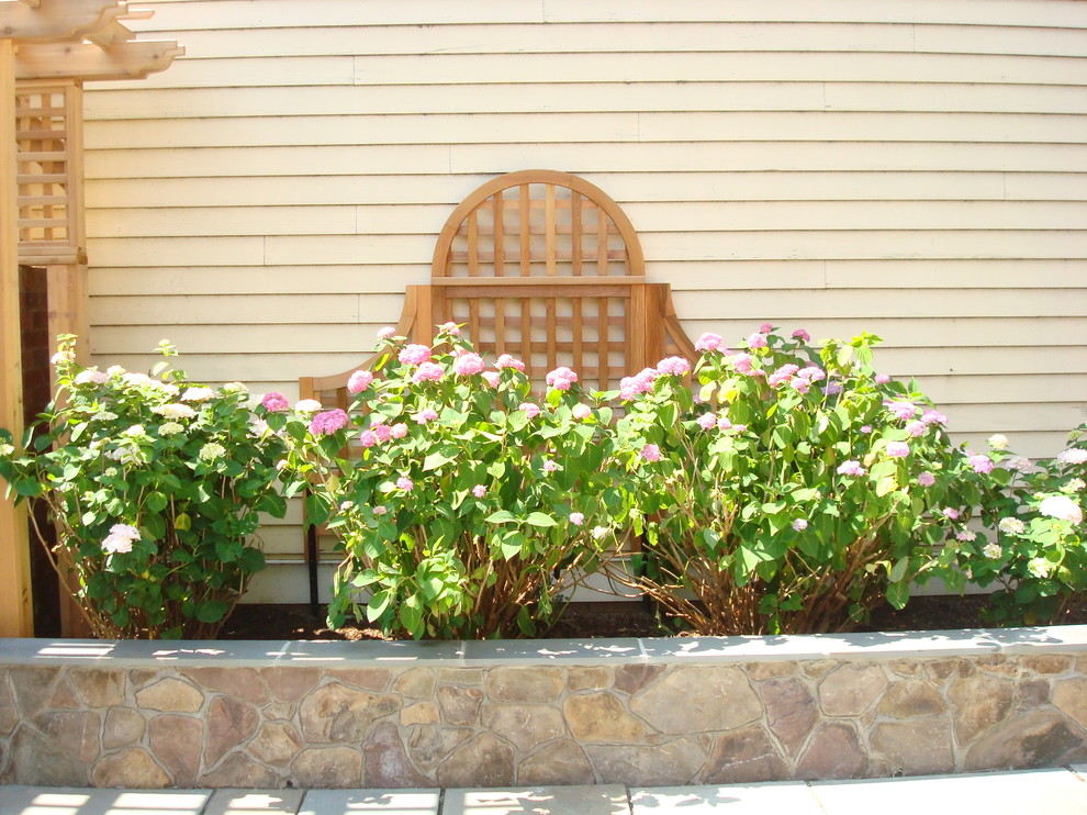 Idée de décoration pour un mur végétal de terrasse design de taille moyenne avec une cour, des pavés en pierre naturelle et aucune couverture.