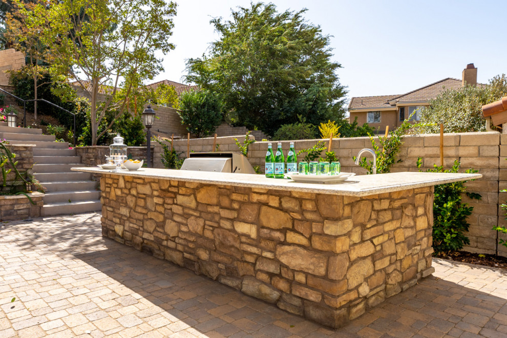 Inspiration for a huge mediterranean backyard stone patio kitchen remodel in Los Angeles