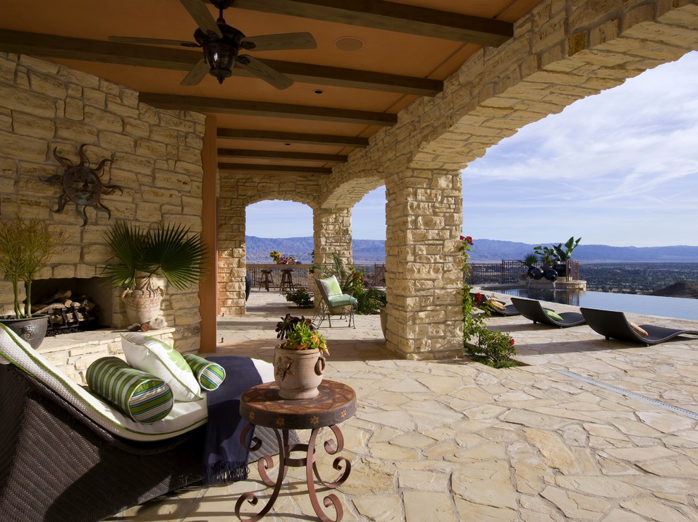 Inspiration pour une terrasse méditerranéenne avec un foyer extérieur et une extension de toiture.