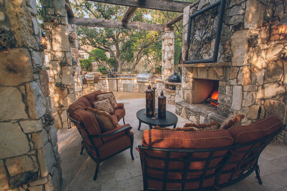 Example of a mid-sized classic backyard stone patio kitchen design in Austin with a pergola