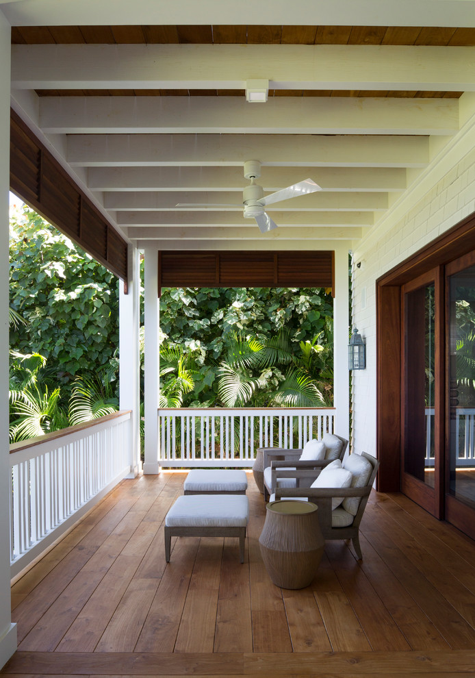 Immagine di un grande patio o portico tropicale dietro casa con pedane e un tetto a sbalzo
