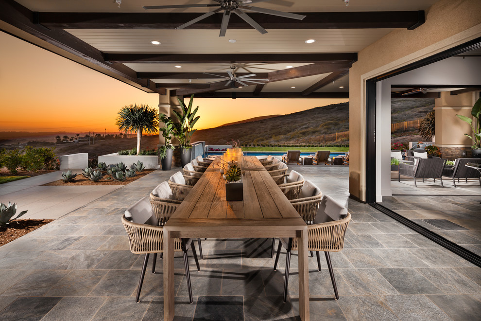 This is an example of a contemporary patio in San Diego with tiled flooring and a roof extension.