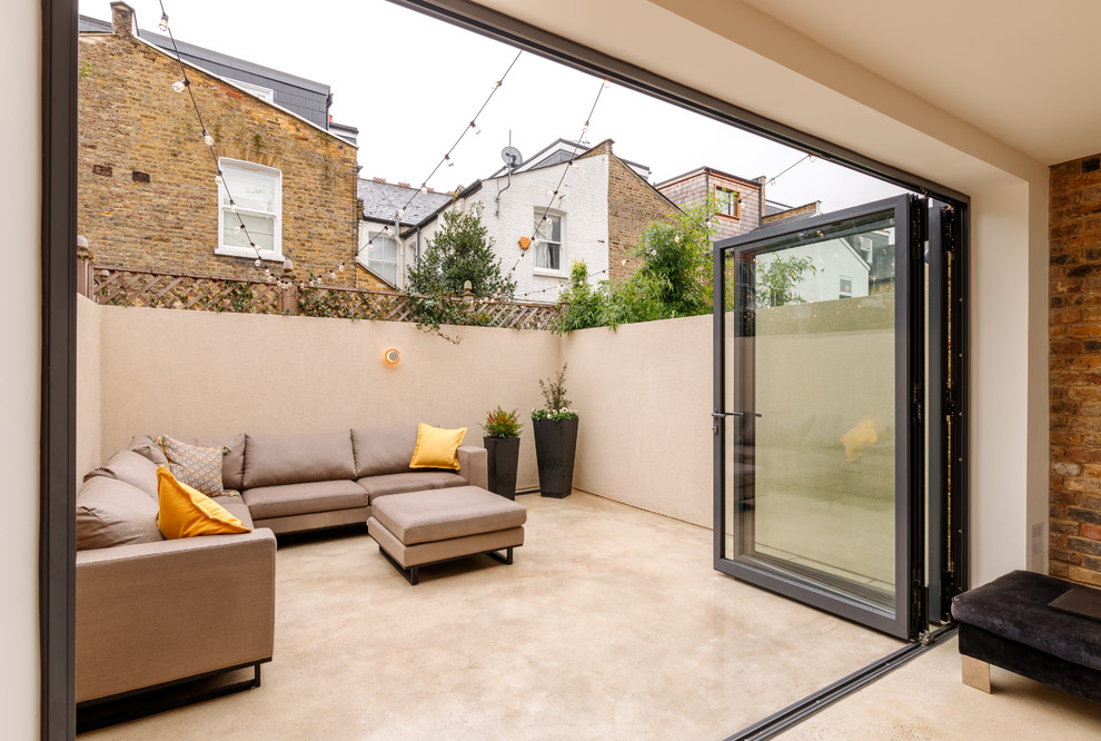 Inspiration for a medium sized contemporary back patio in London with a potted garden.
