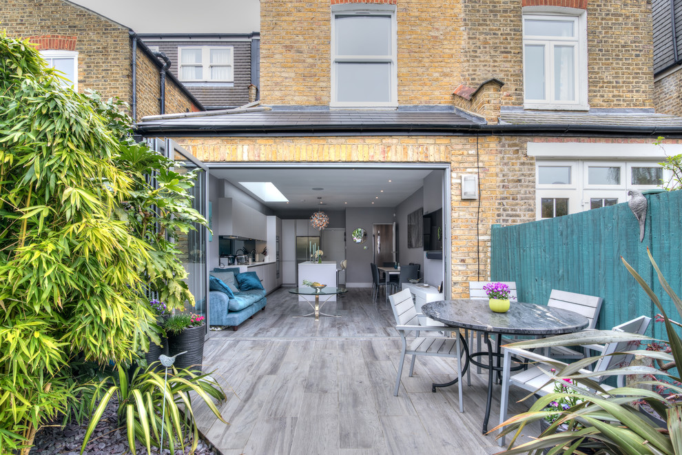 Mittelgroßer, Unbedeckter Moderner Patio hinter dem Haus mit Kübelpflanzen in Sonstige