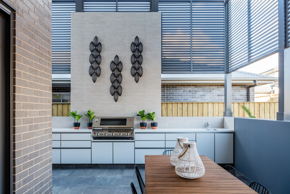 Patio kitchen - large contemporary tile patio kitchen idea in Sydney