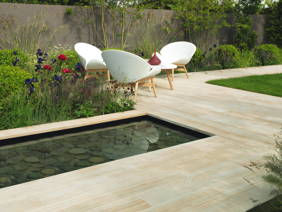Design ideas for a modern back patio in Orange County with a water feature and natural stone paving.