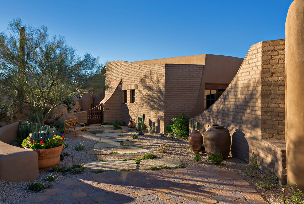 Mid-sized southwest backyard stone patio photo in Phoenix with a fire pit and a roof extension