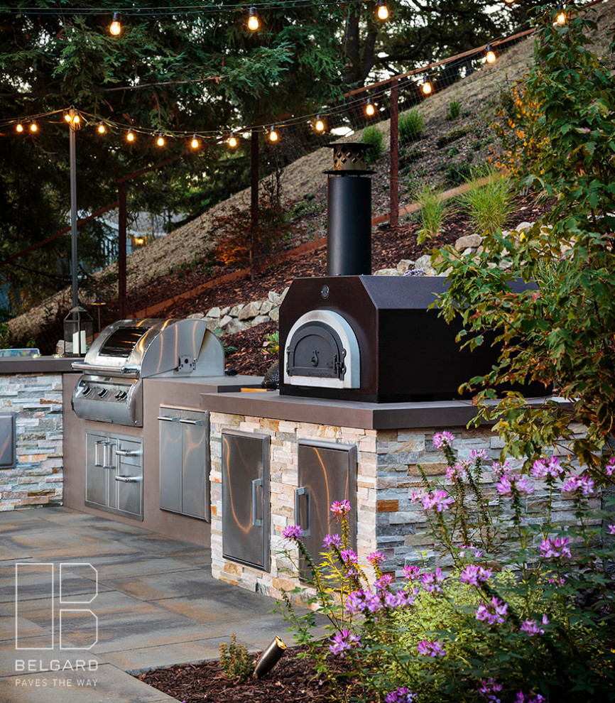 Idée de décoration pour une grande terrasse arrière minimaliste avec une cuisine d'été et des pavés en béton.