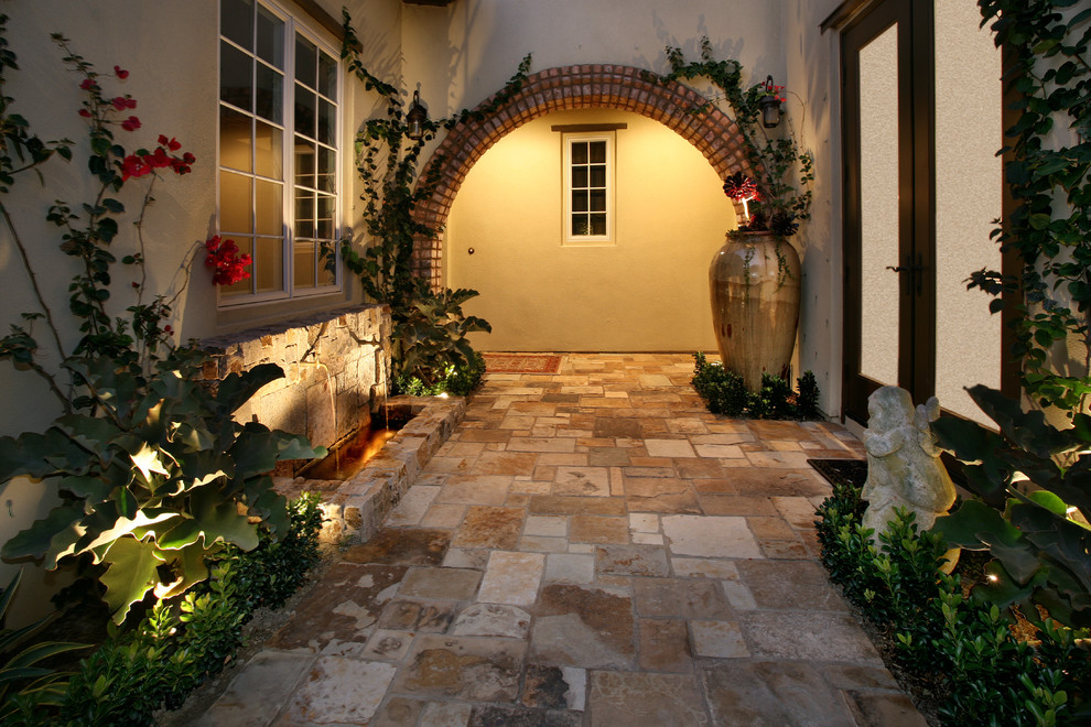 Exemple d'une terrasse latérale tendance de taille moyenne avec un point d'eau, des pavés en pierre naturelle et un gazebo ou pavillon.