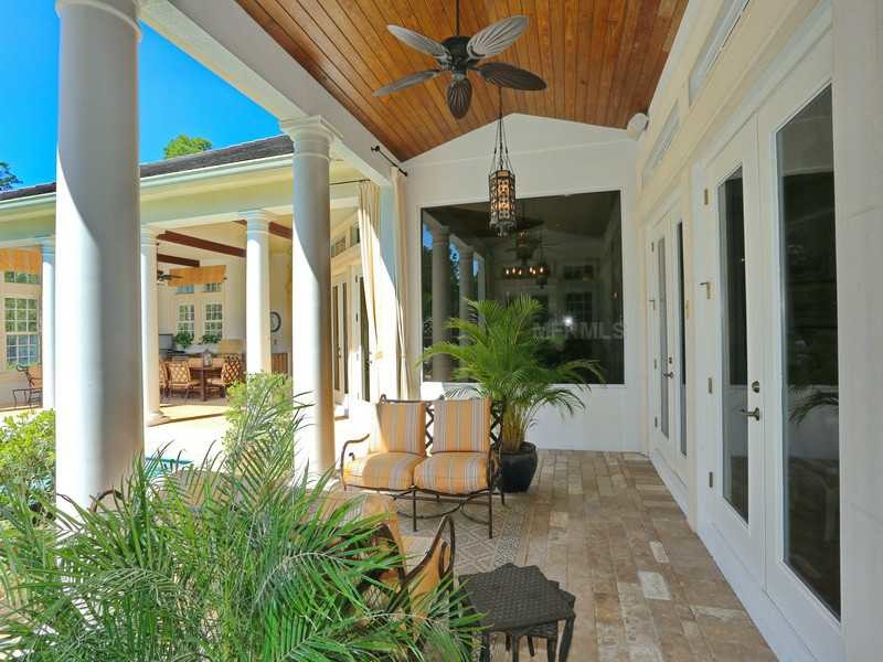 Esempio di un patio o portico tropicale di medie dimensioni e dietro casa con pavimentazioni in pietra naturale e un tetto a sbalzo