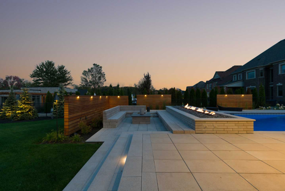 Idée de décoration pour une grande terrasse arrière design avec un point d'eau, des pavés en béton et aucune couverture.