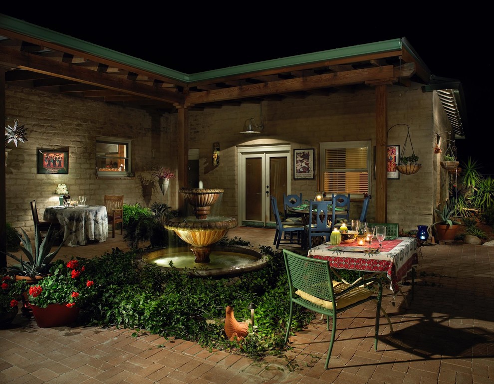 Large mediterranean back patio in Phoenix with an outdoor kitchen, brick paving and no cover.
