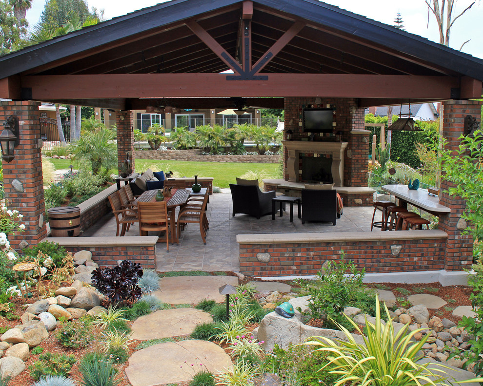 Foto di un grande patio o portico stile americano dietro casa con un focolare, pavimentazioni in pietra naturale e un gazebo o capanno