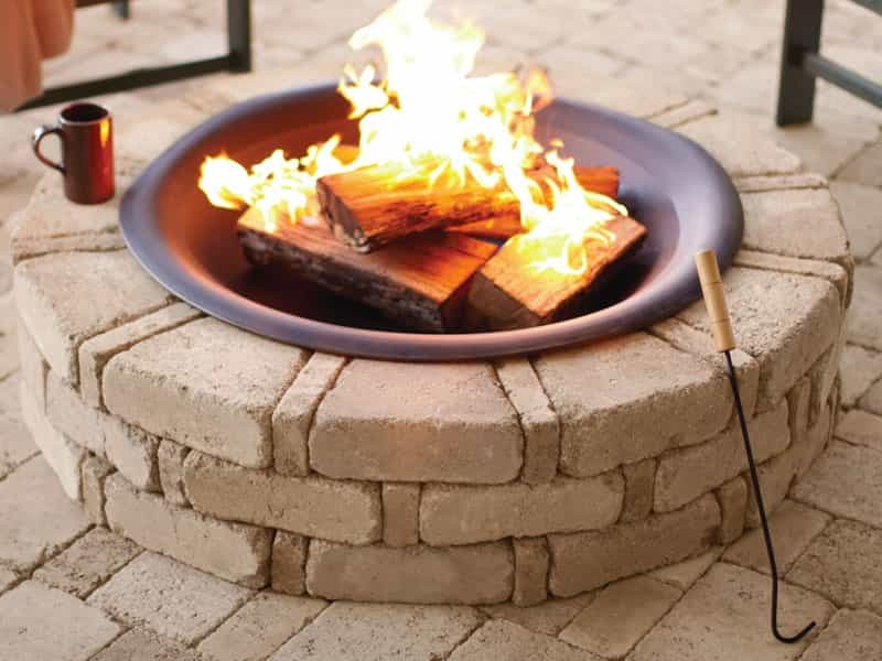 Photo of a medium sized rustic back patio in Other with a fire feature, brick paving and no cover.