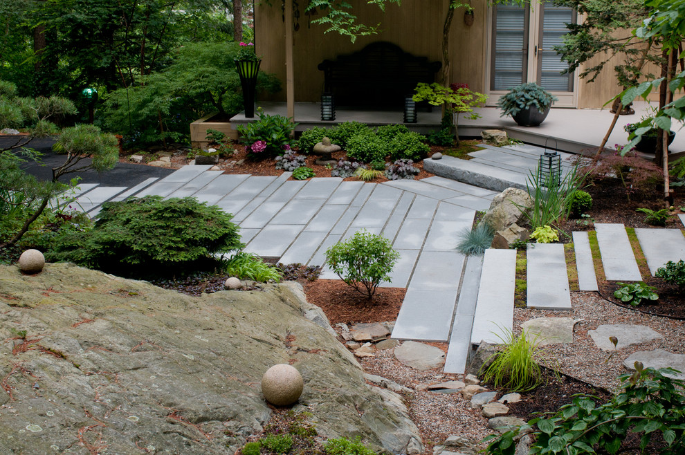 Design ideas for a small world-inspired back patio in Boston with natural stone paving, a water feature and no cover.
