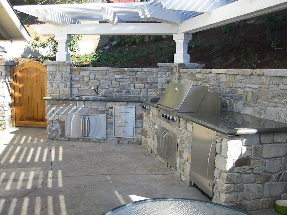 Exempel på en mellanstor klassisk uteplats på baksidan av huset, med utekök, betongplatta och en pergola