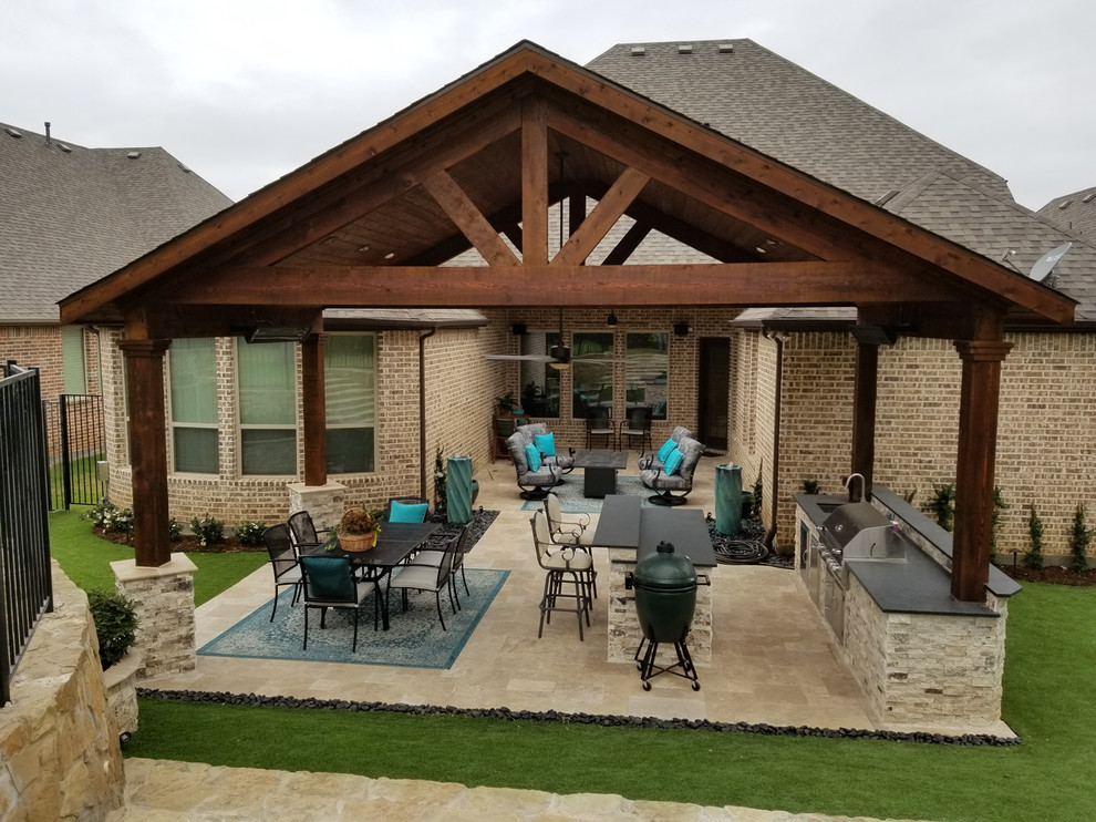 Large classic back patio in Dallas with an outdoor kitchen, natural stone paving and a gazebo.