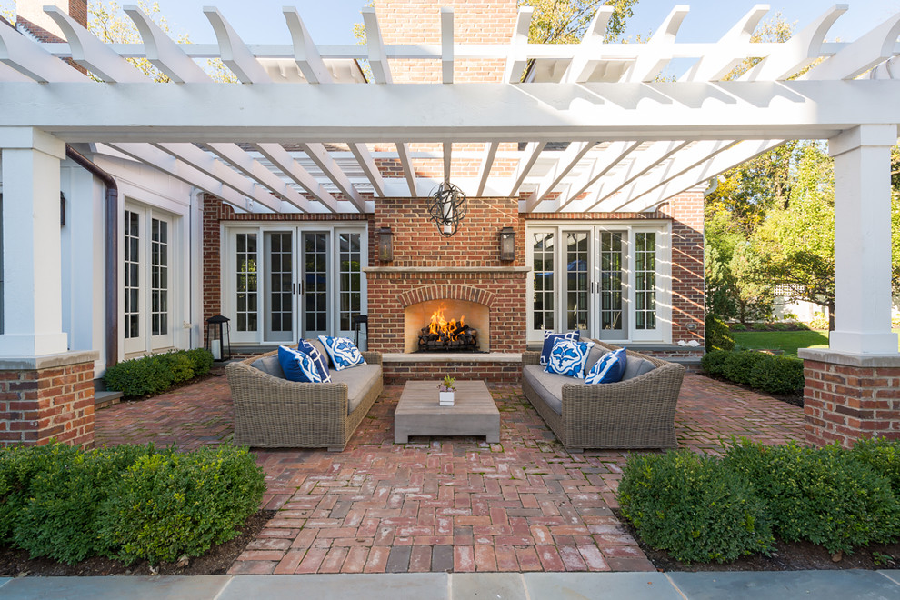 Foto de patio clásico grande en patio trasero con brasero, adoquines de ladrillo y pérgola