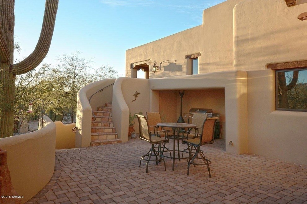 Esempio di un patio o portico american style di medie dimensioni e dietro casa con pavimentazioni in mattoni e un tetto a sbalzo