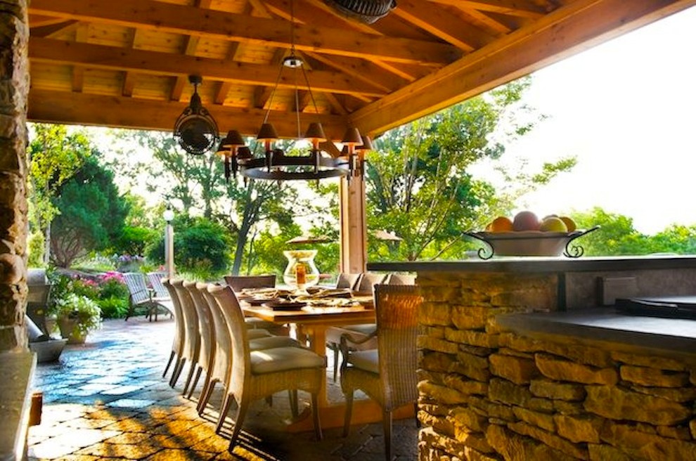 Modelo de patio mediterráneo en patio trasero con cocina exterior, adoquines de piedra natural y pérgola