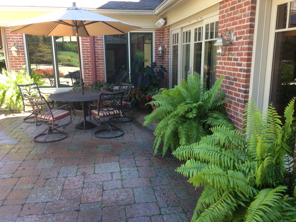 Foto di un patio o portico tradizionale nel cortile laterale con un giardino in vaso e pavimentazioni in cemento