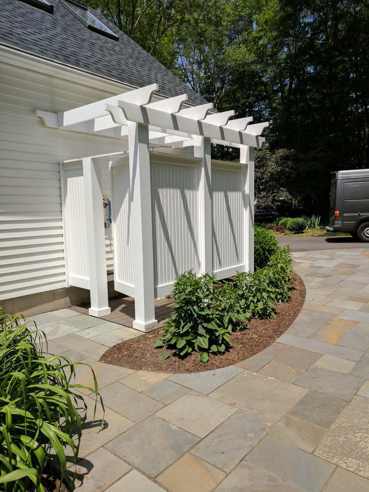 Imagen de patio clásico pequeño en patio trasero con ducha exterior, entablado y pérgola