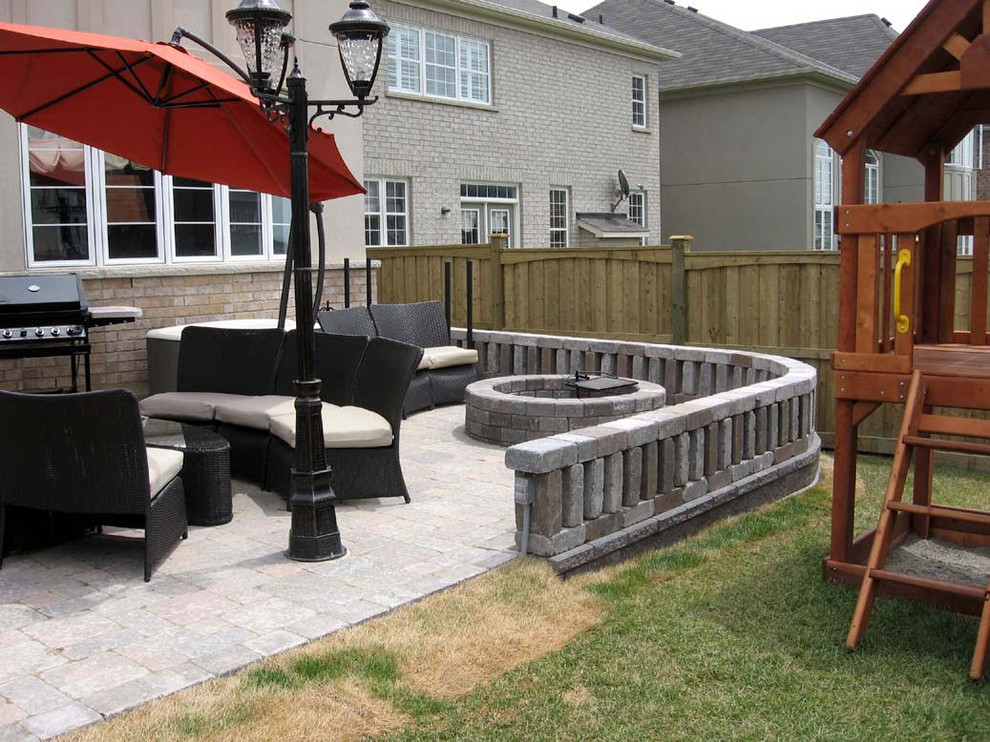 Immagine di un patio o portico design di medie dimensioni e dietro casa con un focolare, pavimentazioni in cemento e nessuna copertura