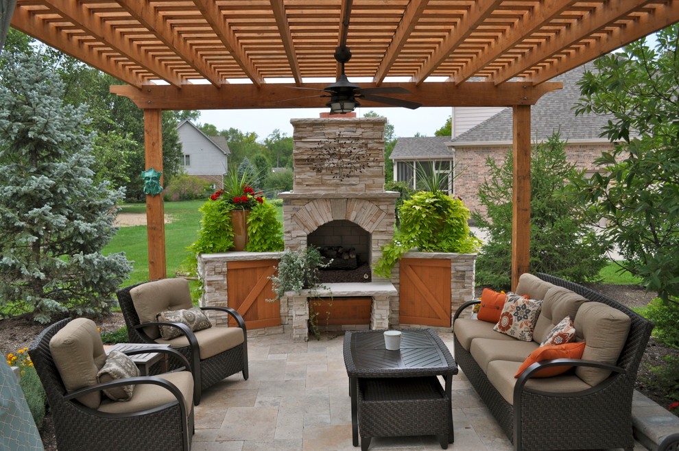 Idee per un patio o portico classico dietro casa e di medie dimensioni con un focolare, una pergola e pavimentazioni in pietra naturale