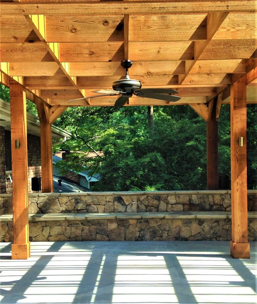Immagine di un patio o portico tradizionale di medie dimensioni e dietro casa con pavimentazioni in pietra naturale e una pergola