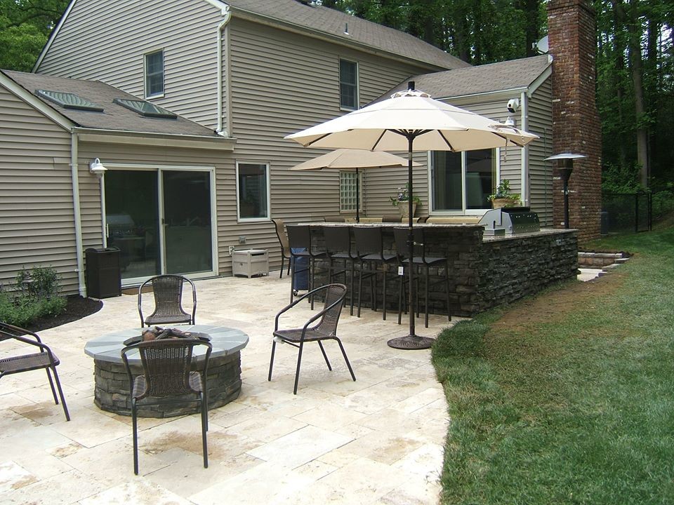 Cette image montre une terrasse arrière craftsman de taille moyenne avec une cuisine d'été, du carrelage et aucune couverture.