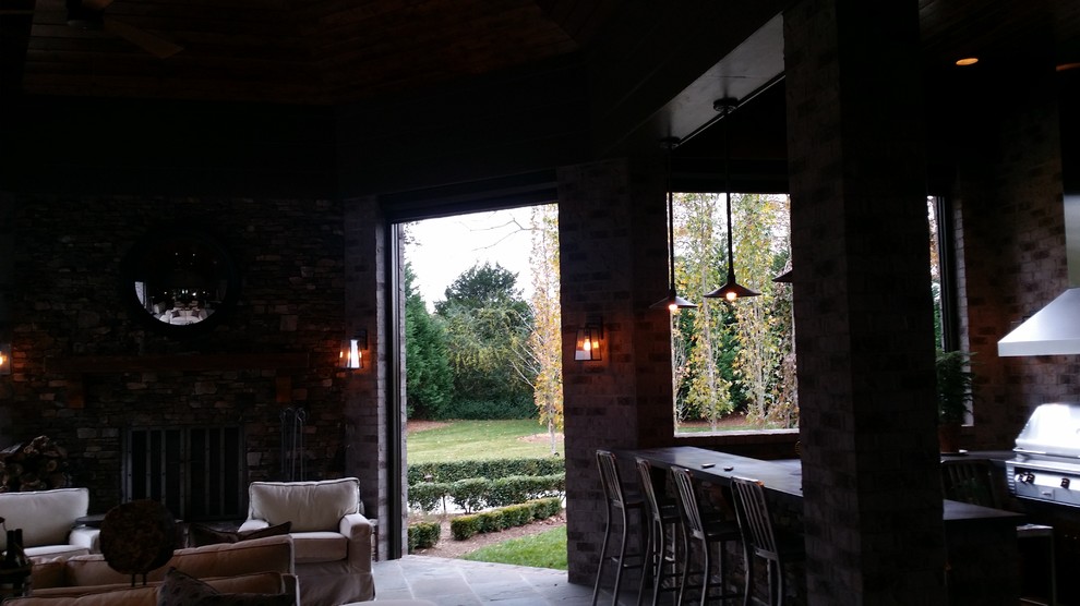 Foto di un grande patio o portico chic dietro casa con un tetto a sbalzo e piastrelle