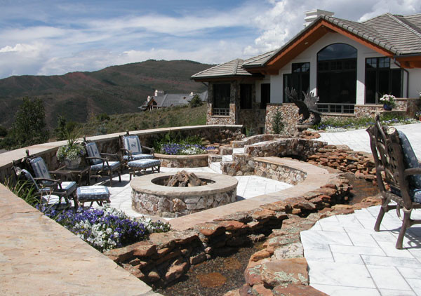 Modelo de patio clásico grande sin cubierta en patio trasero con brasero y adoquines de piedra natural