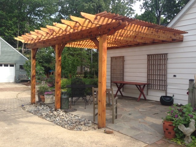 Ispirazione per un patio o portico tradizionale di medie dimensioni e nel cortile laterale con una pergola e pavimentazioni in pietra naturale