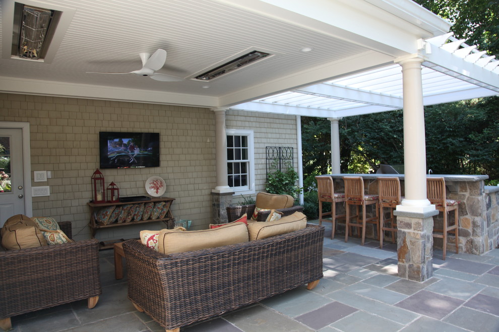 Photo of a medium sized classic back patio in New York with an outdoor kitchen, concrete slabs and a roof extension.