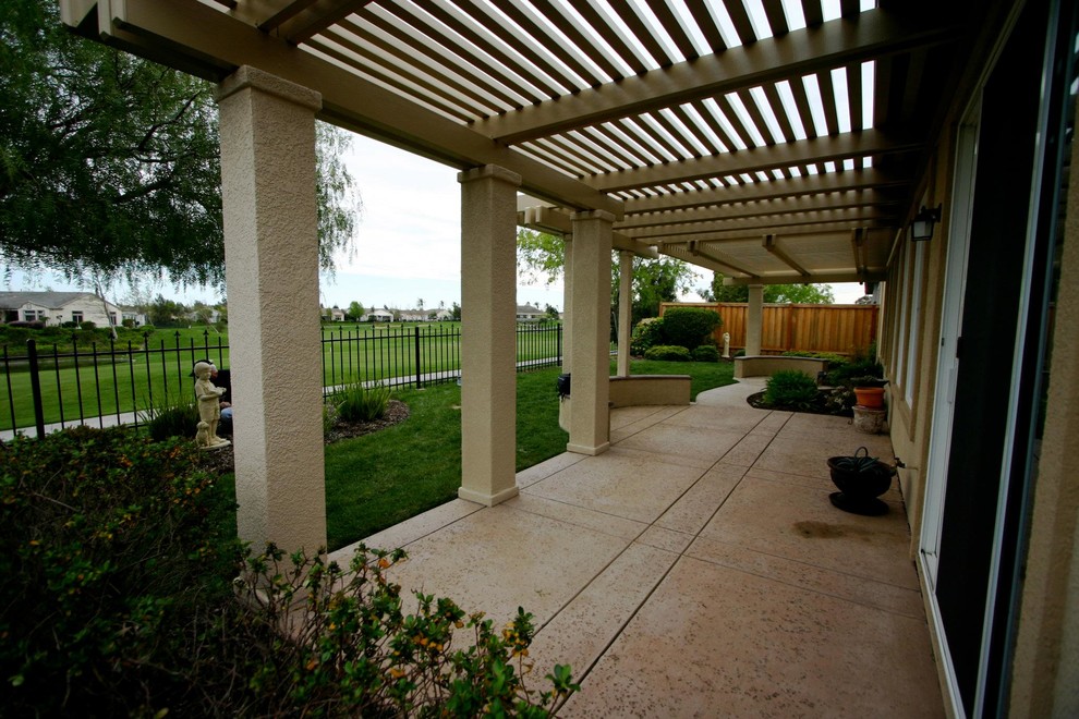 На фото: пергола во дворе частного дома среднего размера на заднем дворе в классическом стиле с покрытием из бетонных плит