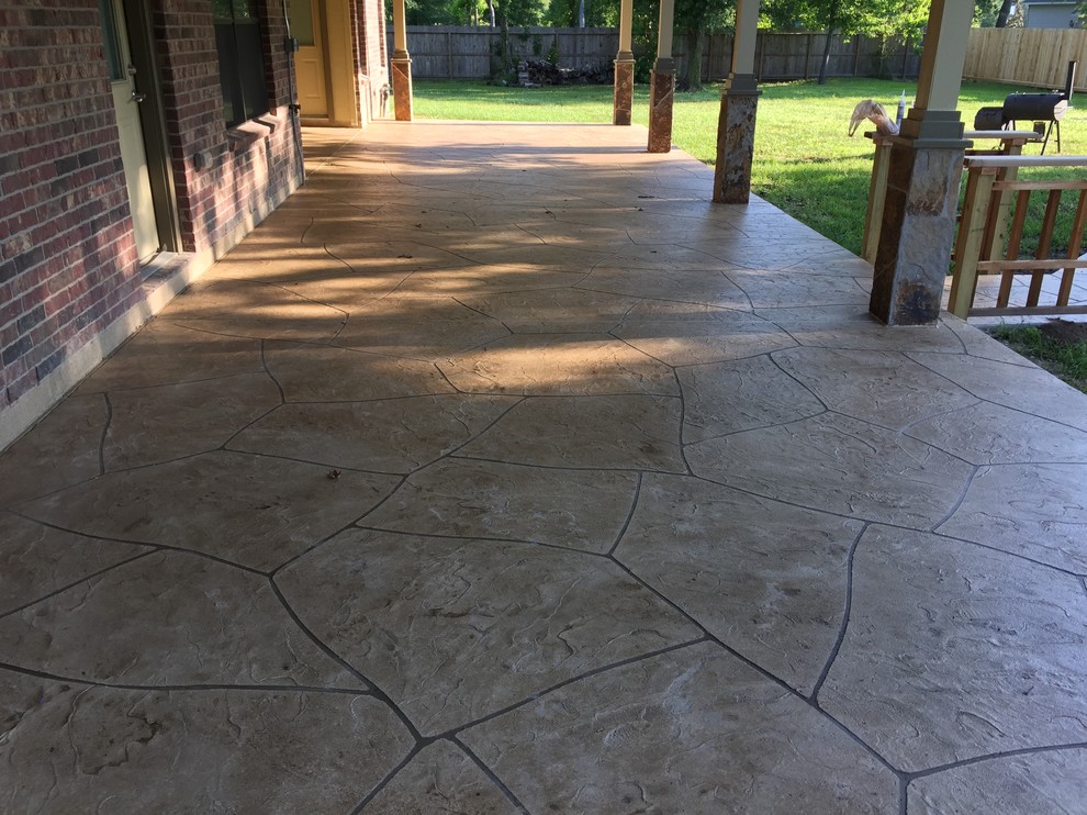 Photo of a large classic back patio in Houston with concrete paving and a roof extension.