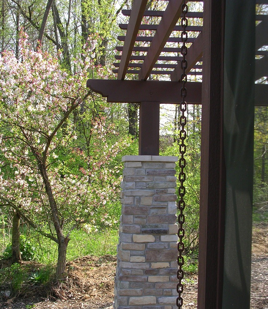 Esempio di un piccolo patio o portico rustico dietro casa con lastre di cemento e una pergola