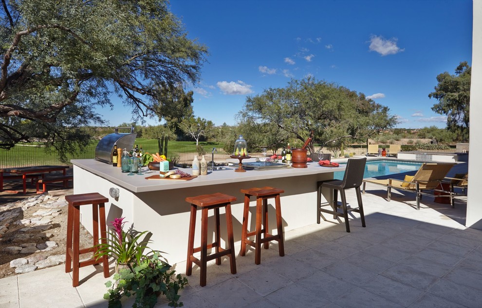 フェニックスにある広いサンタフェスタイルのおしゃれな裏庭のテラス (アウトドアキッチン、タイル敷き、日よけなし) の写真