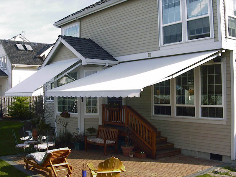 Esempio di un piccolo patio o portico classico dietro casa con pavimentazioni in mattoni e un parasole
