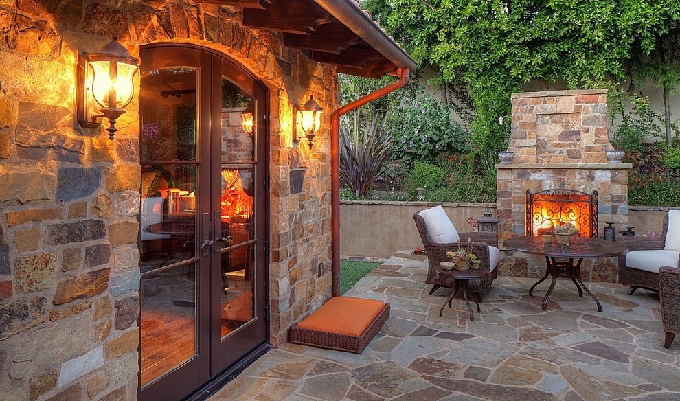 Medium sized mediterranean back patio in Los Angeles with an outdoor kitchen, no cover and natural stone paving.