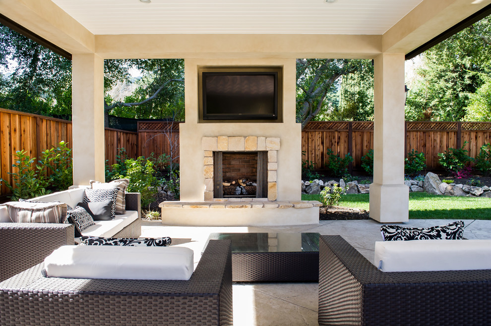 Photo of a large classic back patio in San Francisco with a fire feature, concrete paving and a roof extension.