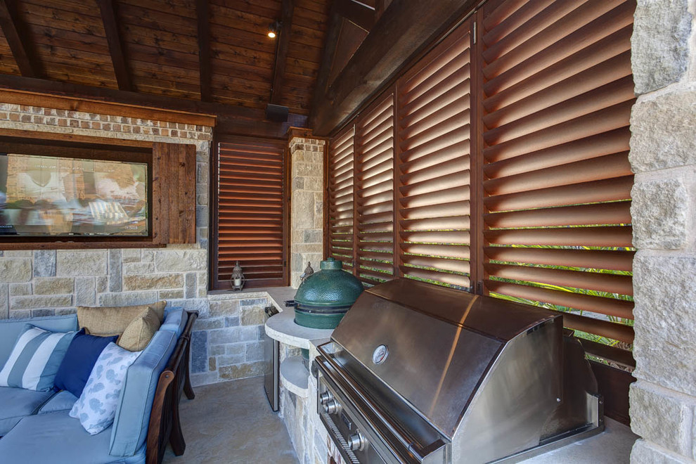 Ejemplo de patio clásico renovado en patio trasero con cocina exterior, losas de hormigón y cenador