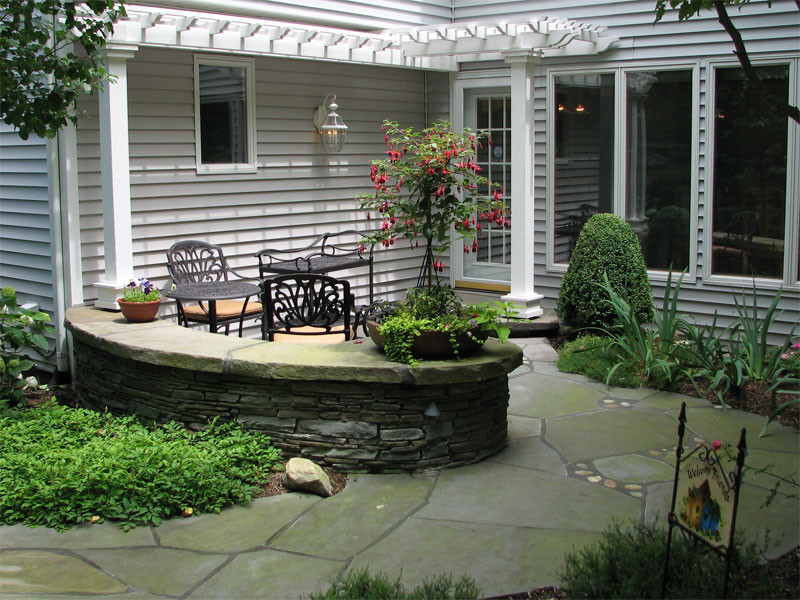 This is an example of a medium sized classic side patio in New York with a pergola.