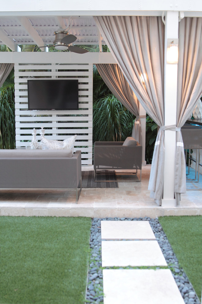 This is an example of a medium sized contemporary back patio in Miami with an outdoor kitchen, natural stone paving and a pergola.